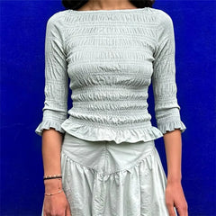 Smocked 3/4 sleeve peplum top in pale green.