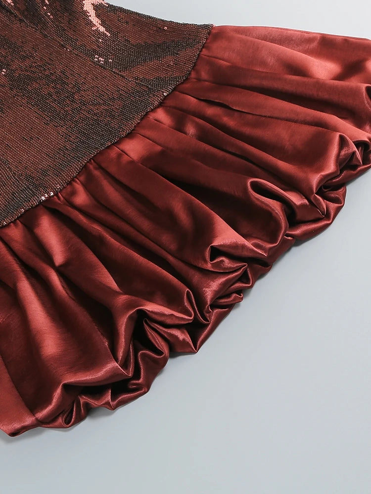 Close-up of a red satin fabric with a textured brown border on a light gray background