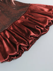 Close-up of a red satin fabric with a textured brown border on a light gray background