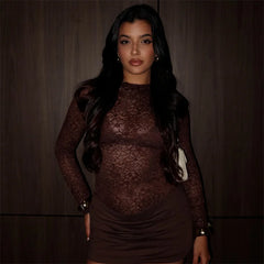 Woman wearing a brown lace dress against a dark background