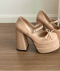 Beige platform shoes with block heels on a wooden floor.