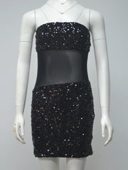 Black sequin dress on a mannequin against a gray background