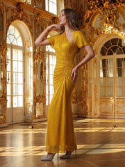 A woman in a gold dress standing in an opulent room with gold decor.