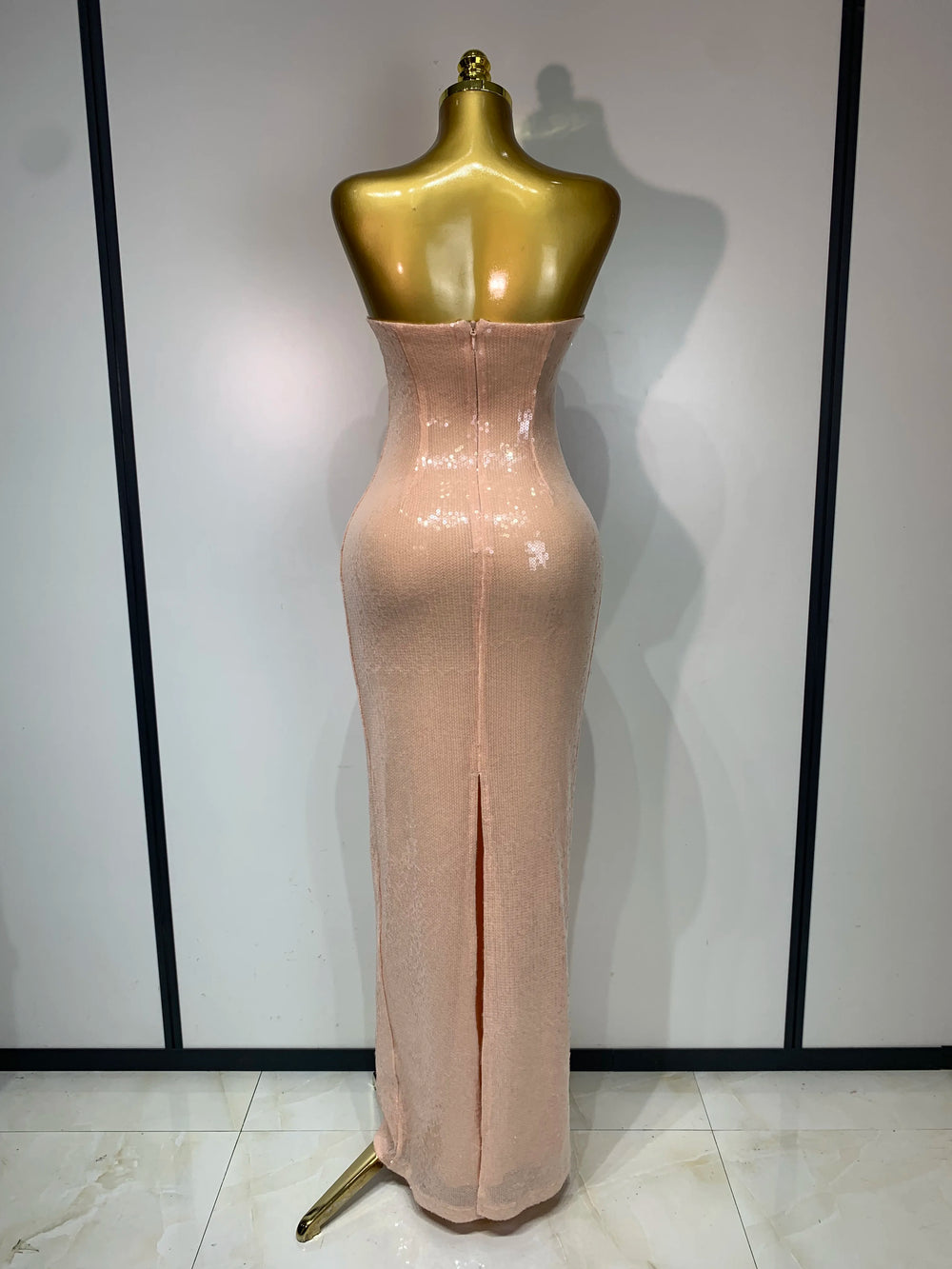 Back view of a strapless sequin column maxi dress with a slit