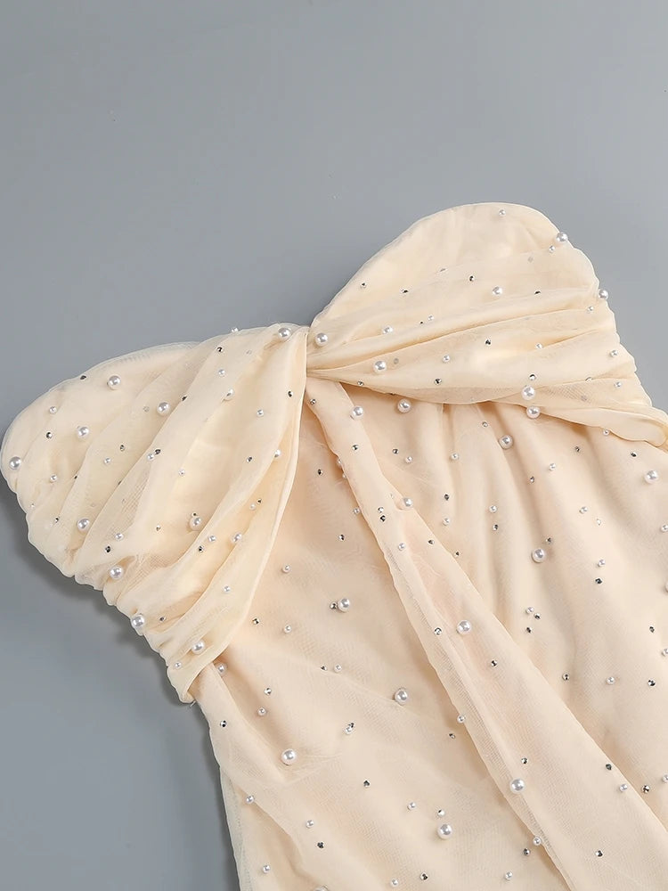 Beige fabric with pearl embellishments on a gray background