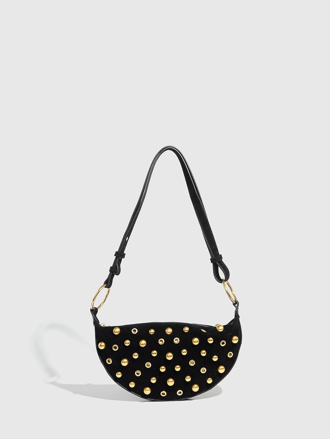 Black handbag with gold studs on a light gray background