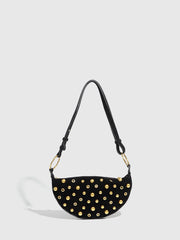 Black handbag with gold studs on a light gray background