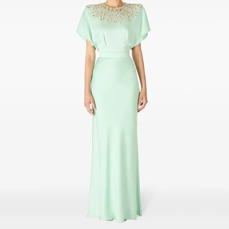 Mint green evening gown with beaded neckline on a white background