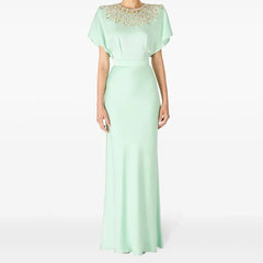 Mint green evening gown with beaded neckline on a white background