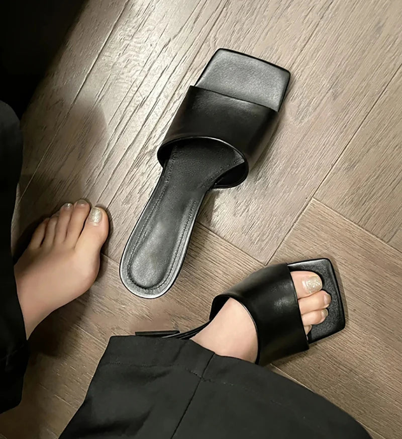 Black sandals on a wooden floor