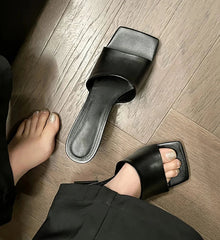 Black sandals on a wooden floor