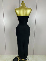 Black evening gown on a gold mannequin against a white wall