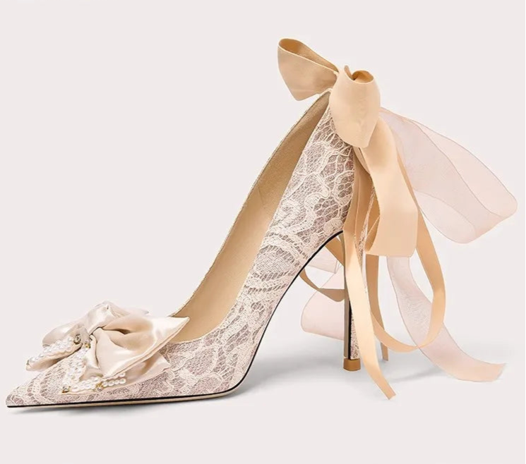 High-heeled shoe with lace design and ribbon on a white background