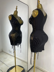 Back view of a black embellished mesh sheath mini dress.