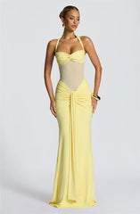 Woman wearing a yellow evening gown on a light gray background