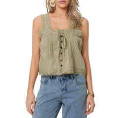 Woman wearing a green sleeveless top with lace details and blue jeans on a white background