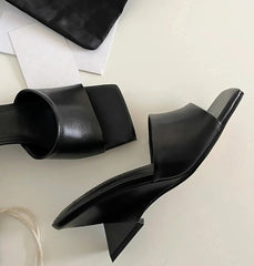 Black high-heeled shoes on a light gray surface
