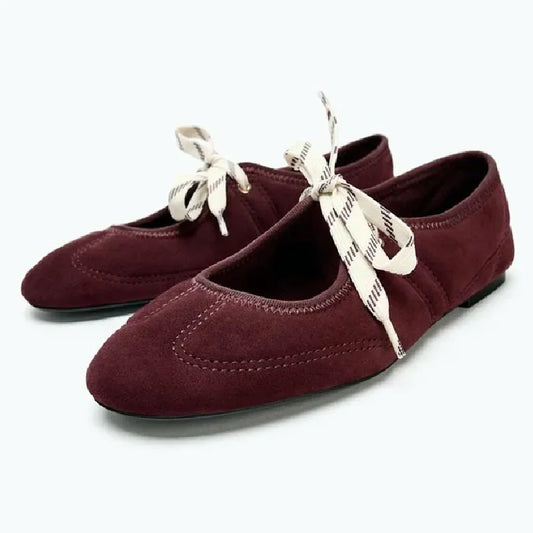 Burgundy faux suede round toe ballet flats with ribbon lace-up detail.