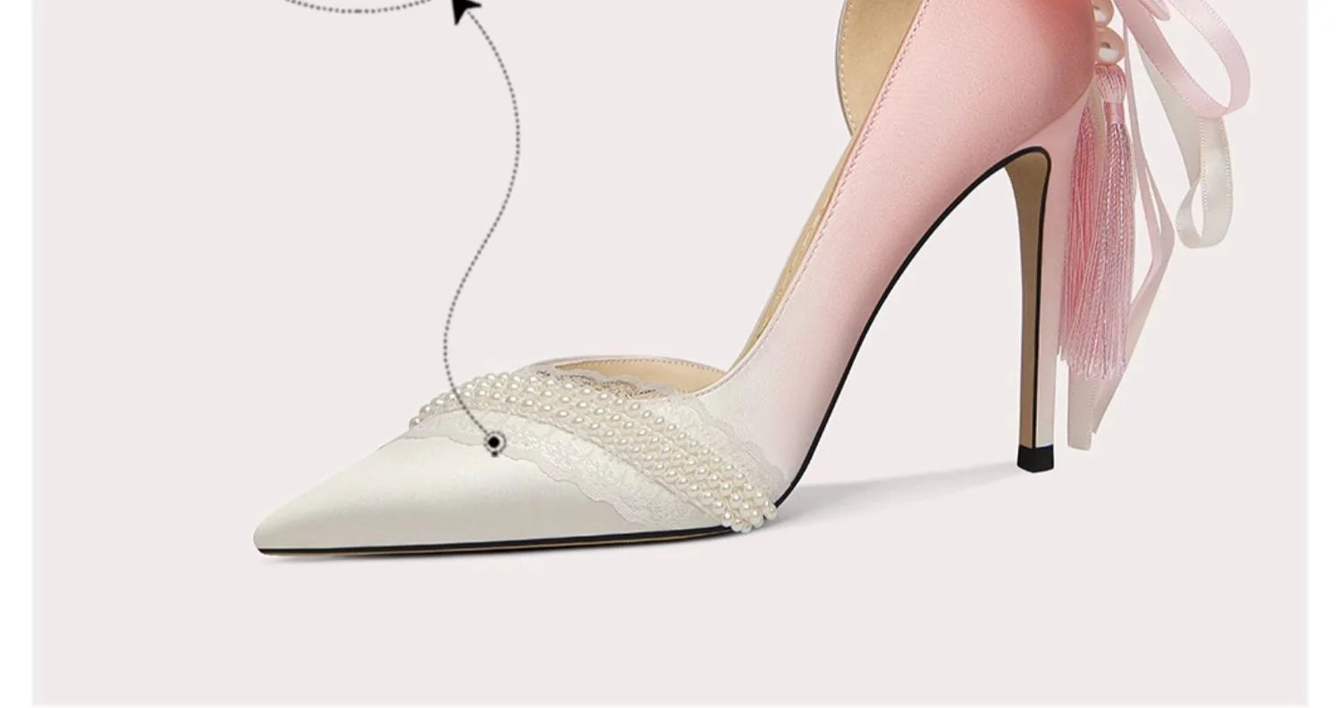 White high-heeled shoes with decorative ribbons on a light background