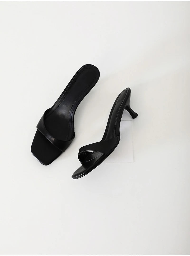 Pair of black high-heeled shoes on a white background