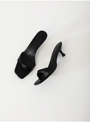 Pair of black high-heeled shoes on a white background