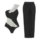 Black one-shoulder swimsuit with feather sequin embellishment and black draped maxi skirt