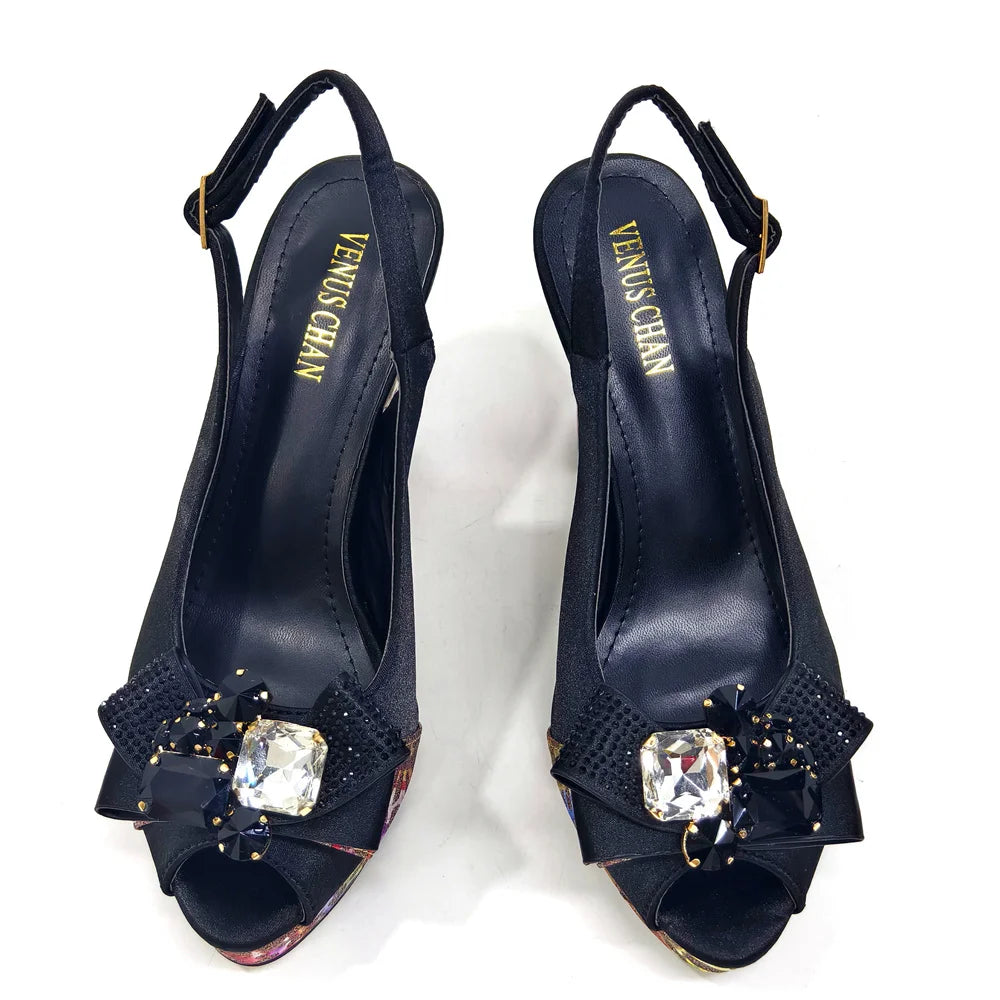 Navy blue high-heeled shoes with gemstones and 'Venus Chain' branding on a white background