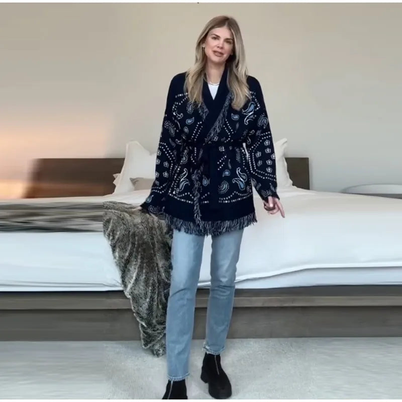 Woman wearing a dark patterned coat in a bedroom setting