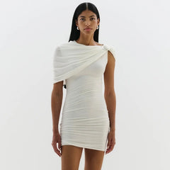 Woman wearing a white one-shoulder dress on a plain background