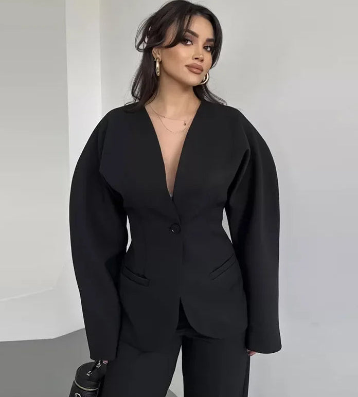 Woman wearing a black suit against a plain background