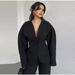 Woman wearing a black suit against a plain background