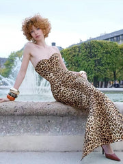 Woman in a leopard print dress sitting by a fountain