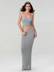 Woman wearing a gray sleeveless top and long skirt