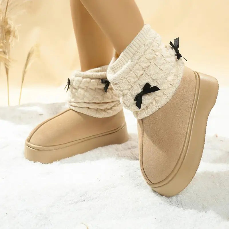 Beige winter boots with white knitted leg warmers and black bows on a snowy background