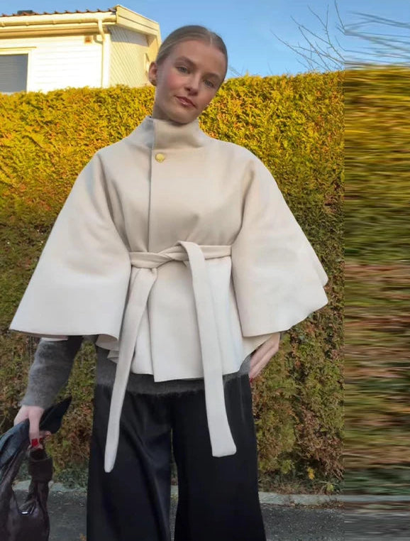 Woman wearing a beige coat with a blurred background