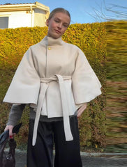 Woman wearing a beige coat with a blurred background