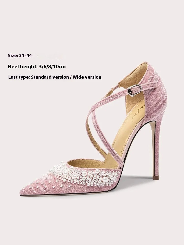 Pink high-heeled shoe with pearl embellishments on a light gray background