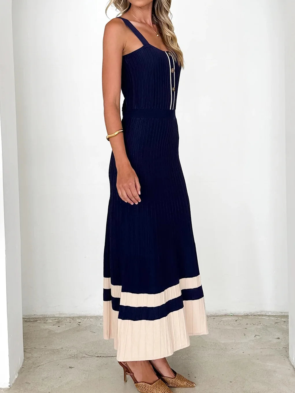 Woman wearing a navy and beige dress against a white background