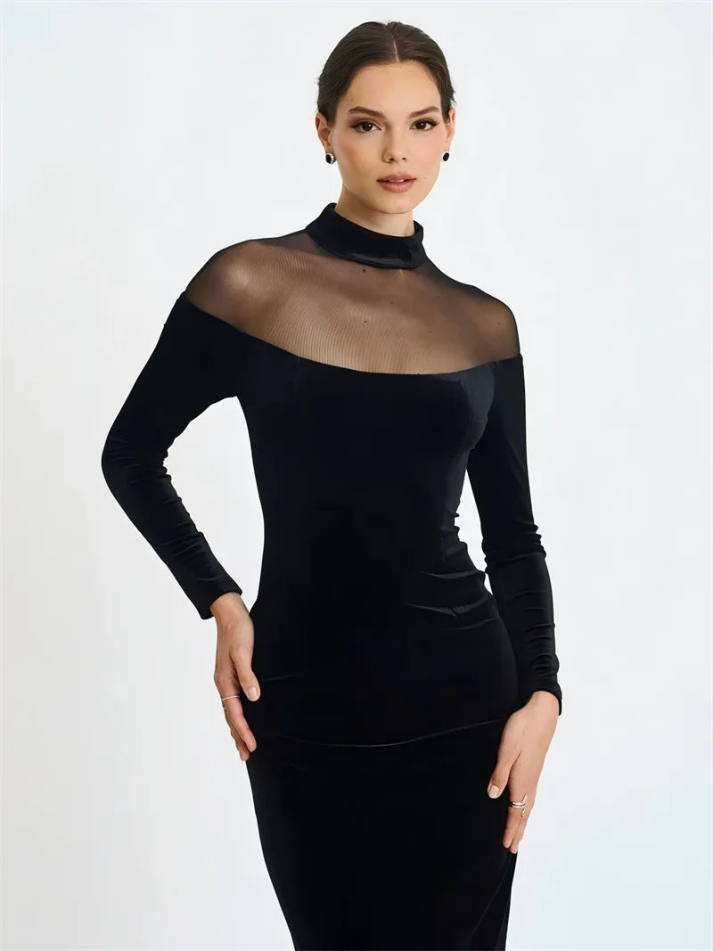 Black dress with sheer neckline worn by a model on a white background