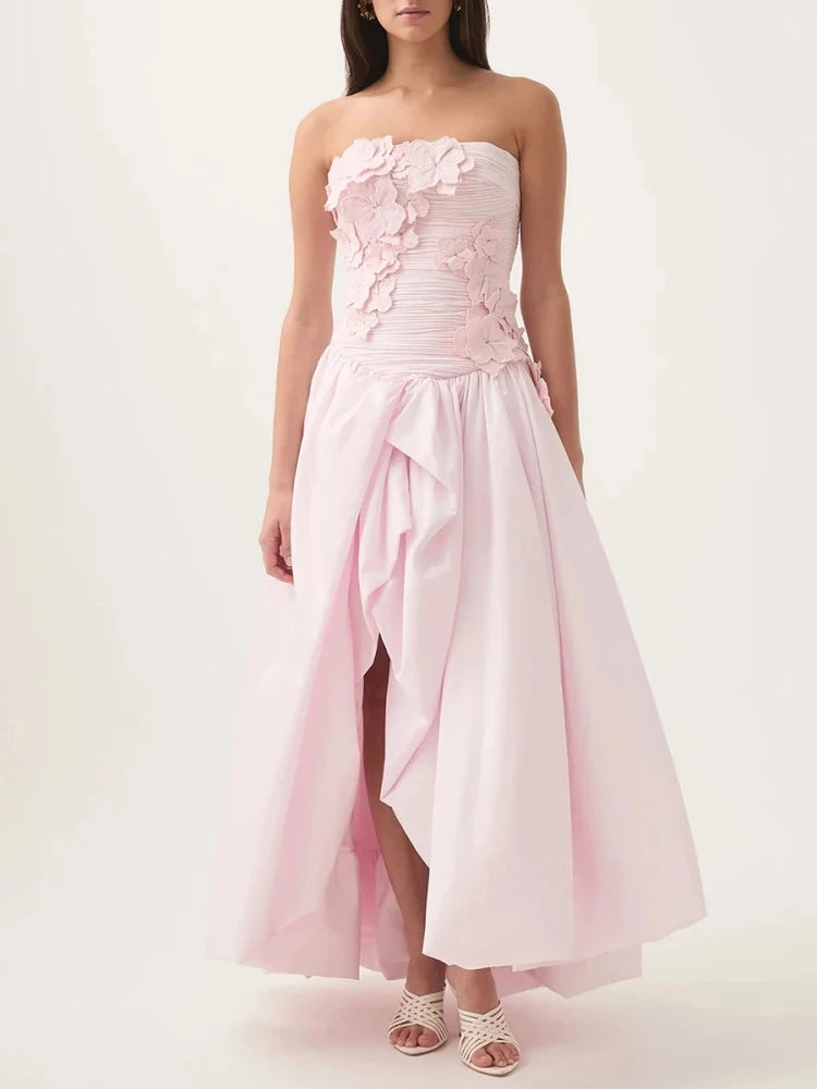 Woman wearing a strapless pink 3D floral dress on a white background