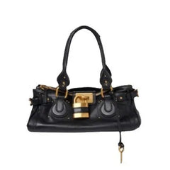 Black leather tote bag with gold lock closure isolated on white.