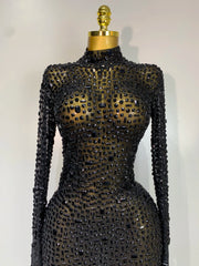 Black beaded dress on a mannequin against a white background