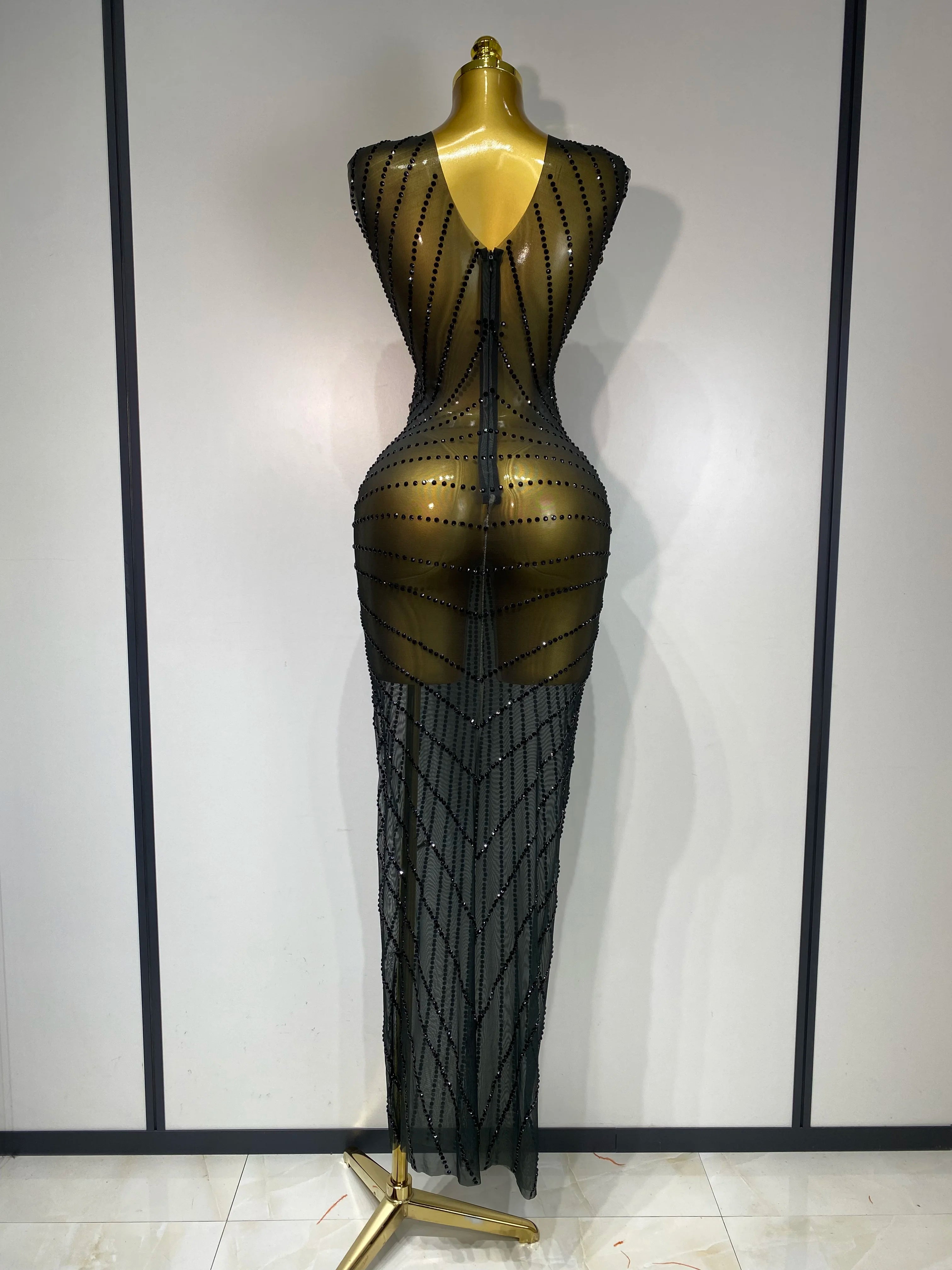 Black beaded evening gown on a mannequin against a plain background