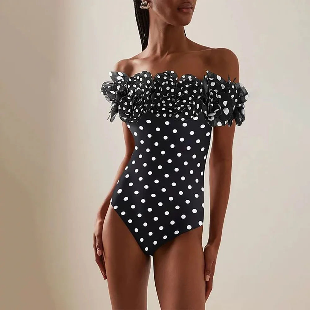 Close-up of the off-the-shoulder ruffled neckline on a polka dot one-piece swimsuit.