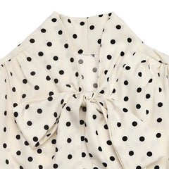 White blouse with black polka dots and a bow detail on a white background