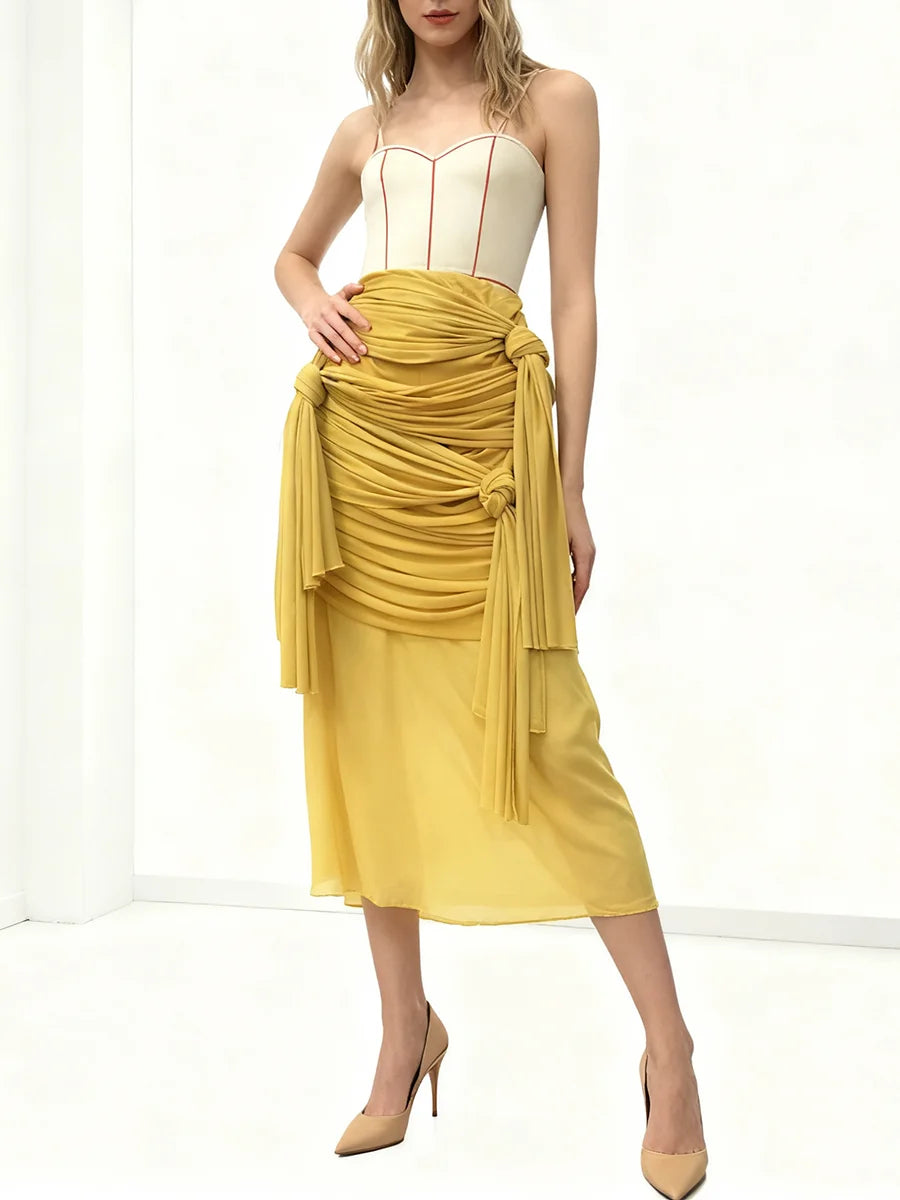 Woman wearing a yellow dress with a white top on a white background