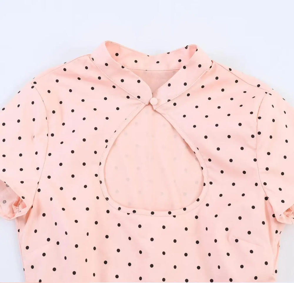 Close-up of pink polka dot cut-out stand collar blouse neckline and cut-out