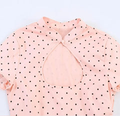 Close-up of pink polka dot cut-out stand collar blouse neckline and cut-out