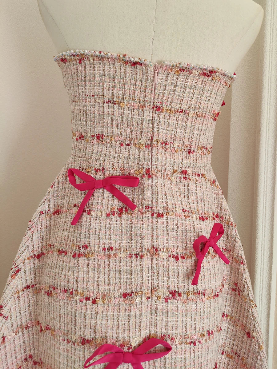 Floral dress with pink bows on a mannequin against a white background