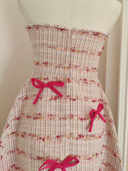 Floral dress with pink bows on a mannequin against a white background